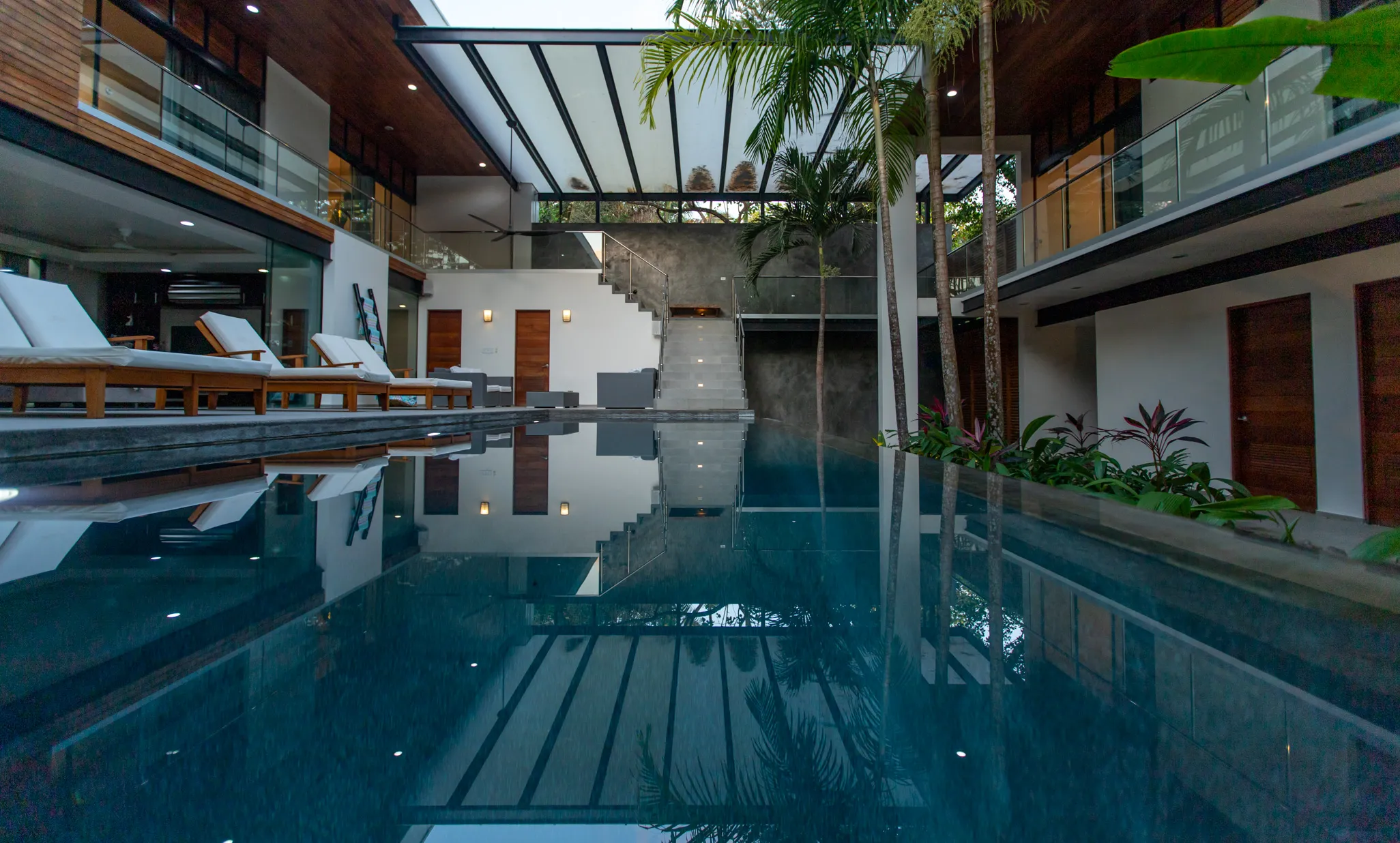 Casa Almendra villa pool courtyard at evening with reflection, Nosara