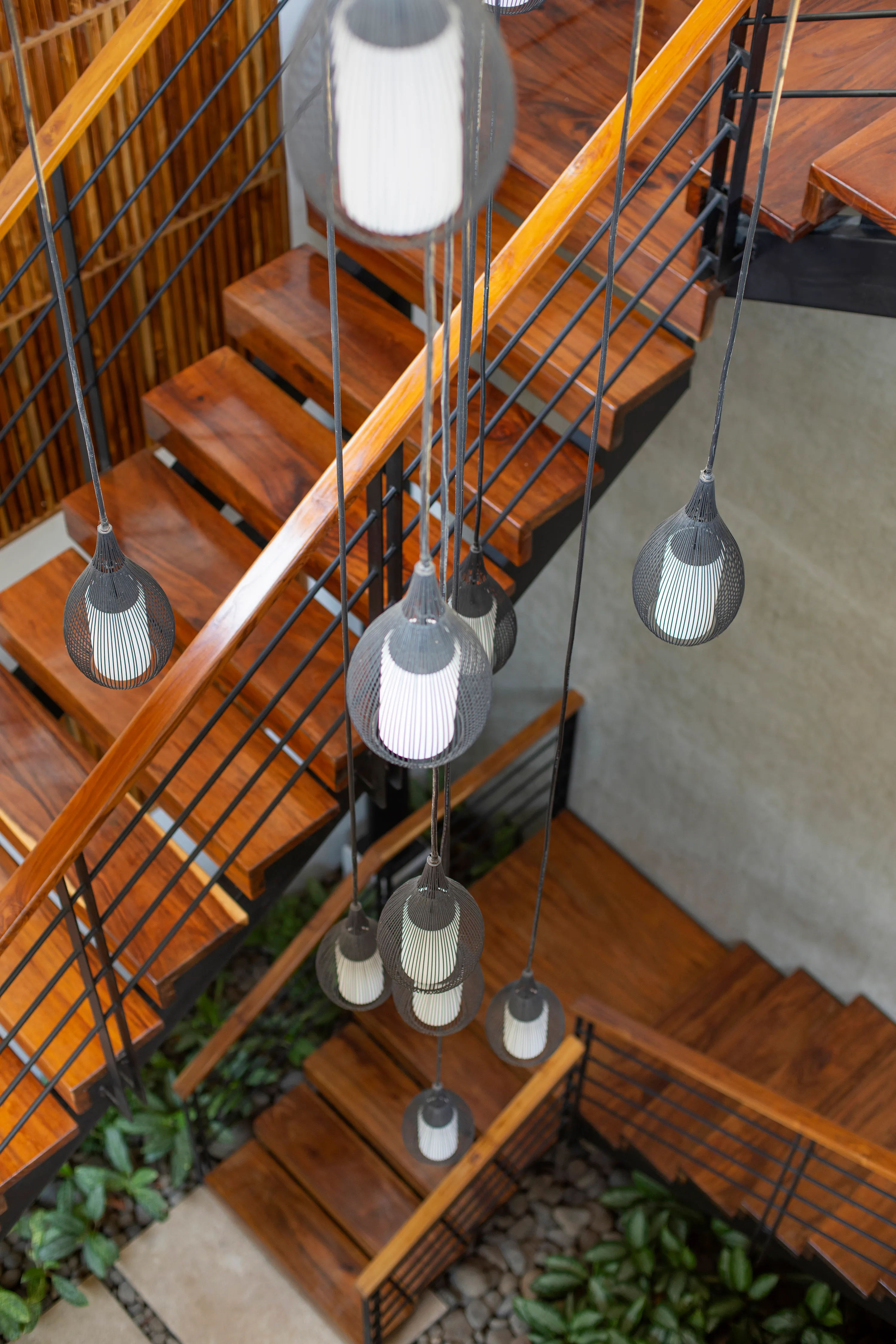 Terrace House villa stairwell with hanging pendant lights, Nosara
