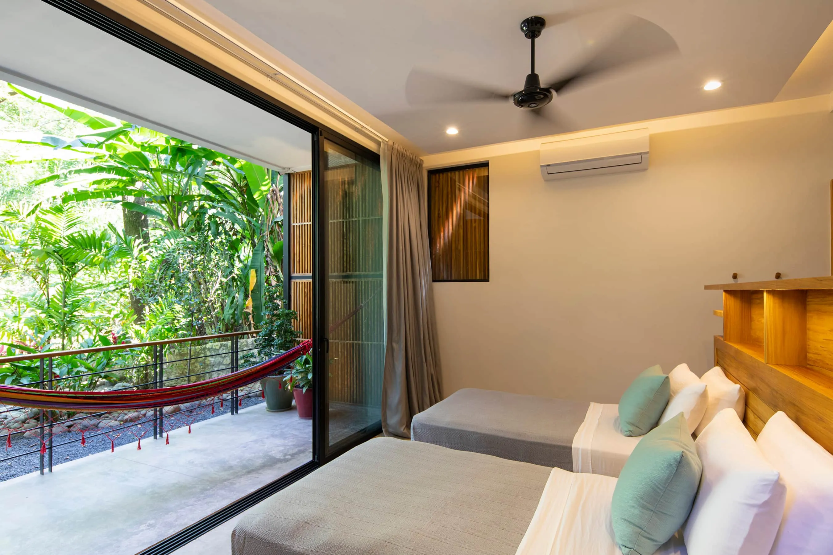 Terrace House villa bedroom with cushioned daybed opening to jungle view, Playa Guiones Nosara