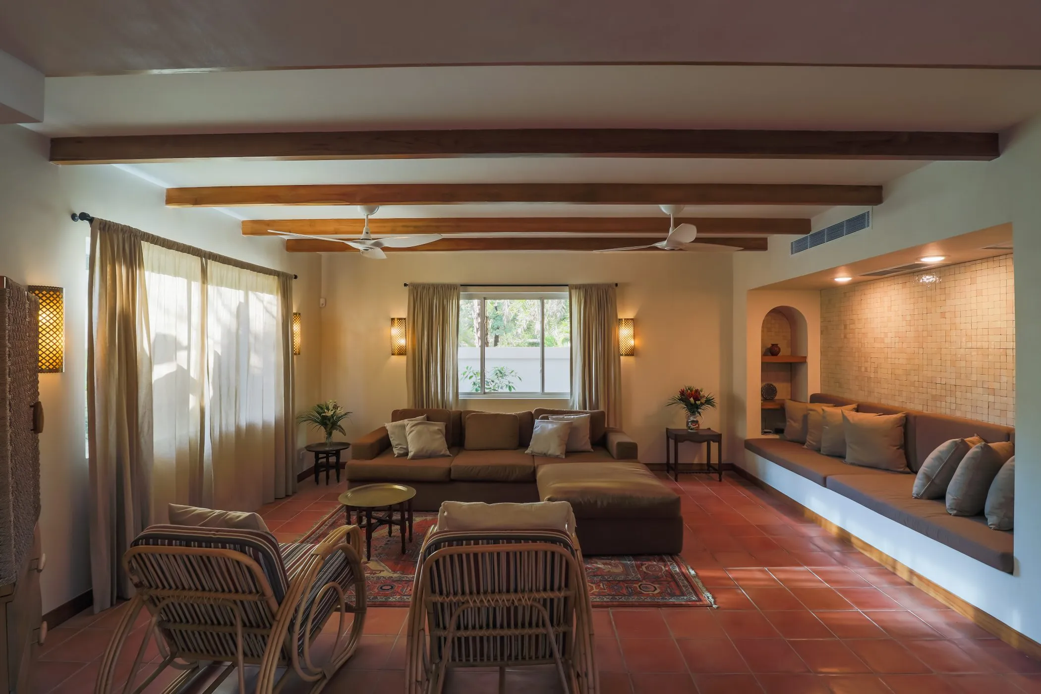 Casa Oceanus villa living room with corner sofa, wood beams, and terracotta floor, Guiones Beach Club Nosara