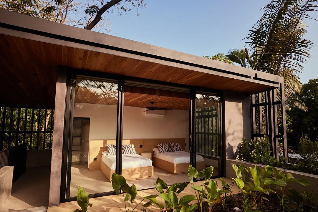Calma House villa pool view framed by wooden privacy screens, North Guiones Nosara