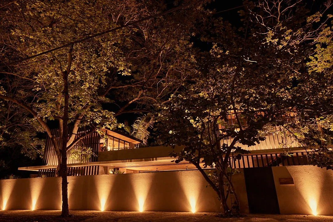 Calma House villa exterior at night with up-lit landscape, Playa Guiones Nosara, Costa Rica