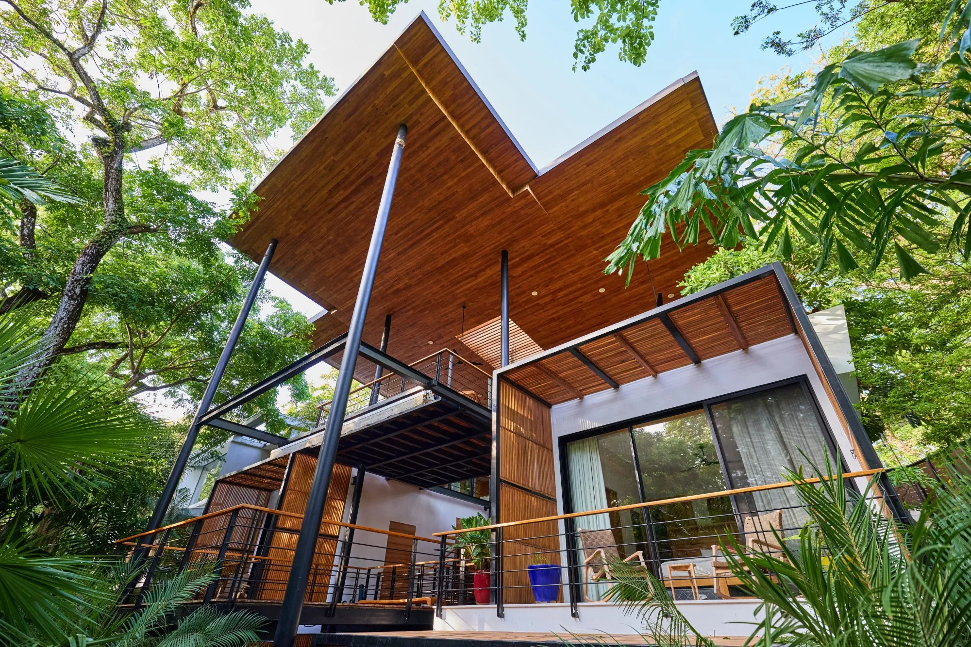 Terrace House villa A-frame architecture exterior emerging from jungle canopy, South Guiones Nosara, Costa Rica