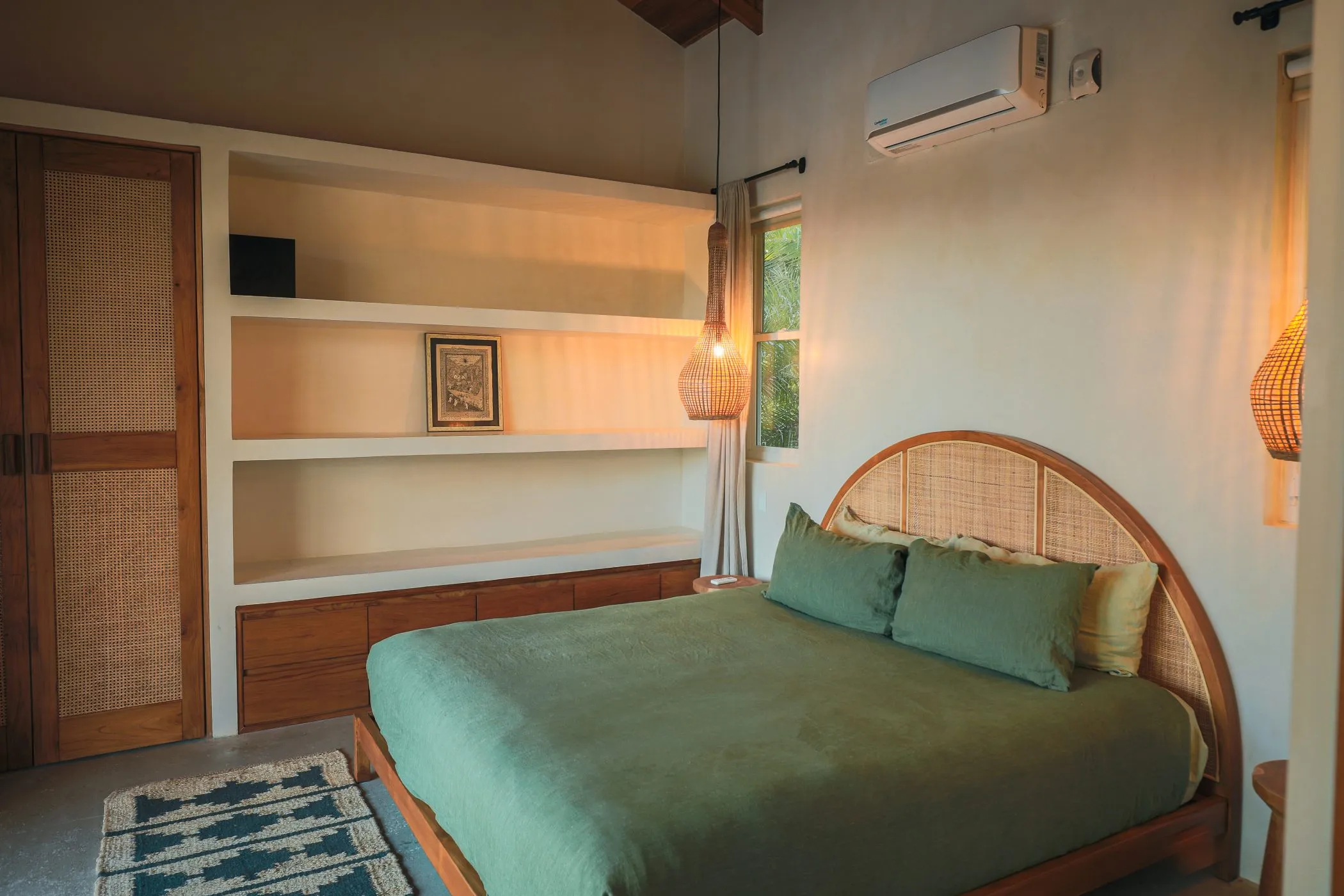 Casa Oceanus villa bedroom with built-in shelving and green bedspread, Nosara