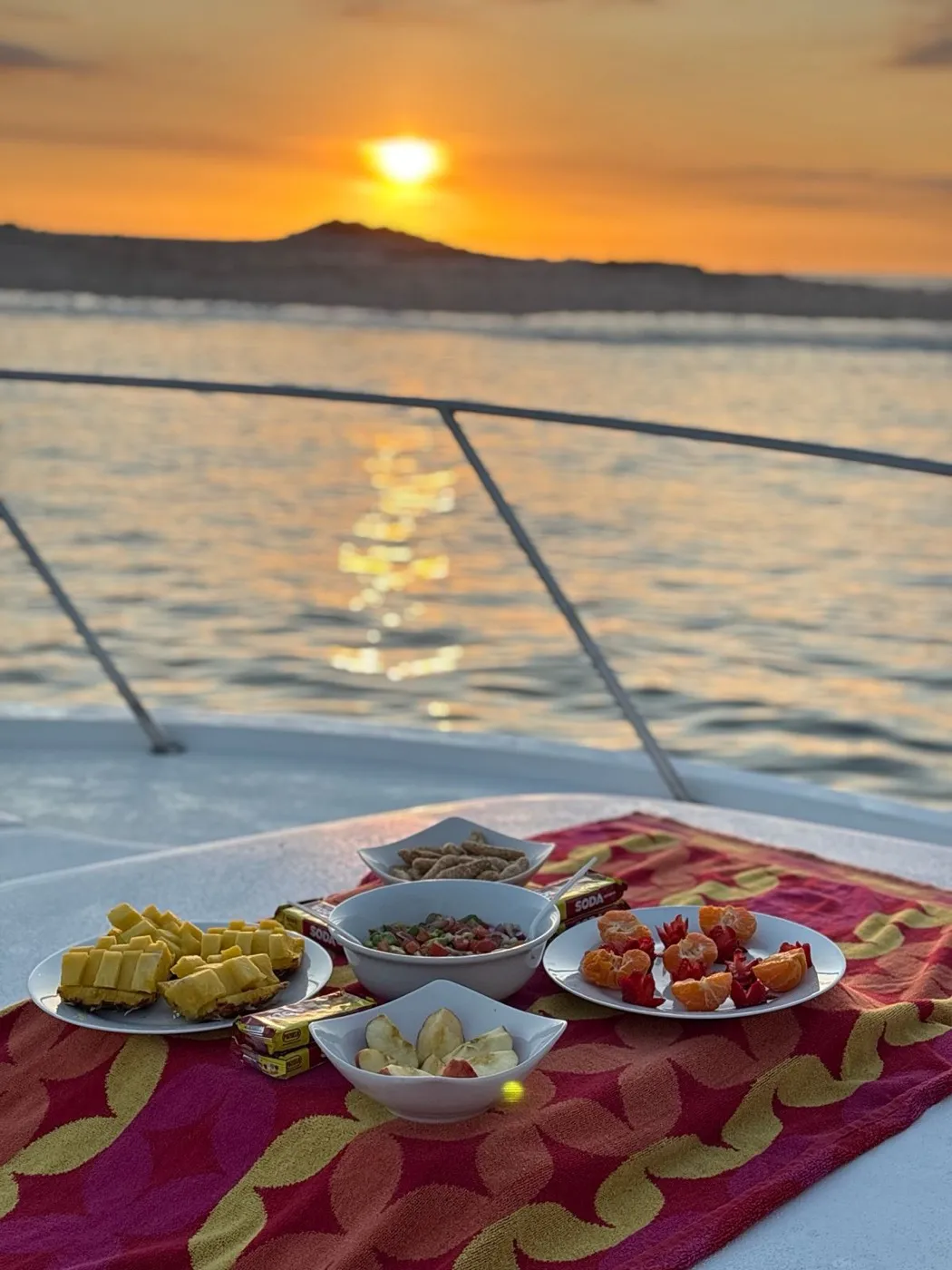Fruit, ceviche, and snacks set out on the bow of the boat at sunset